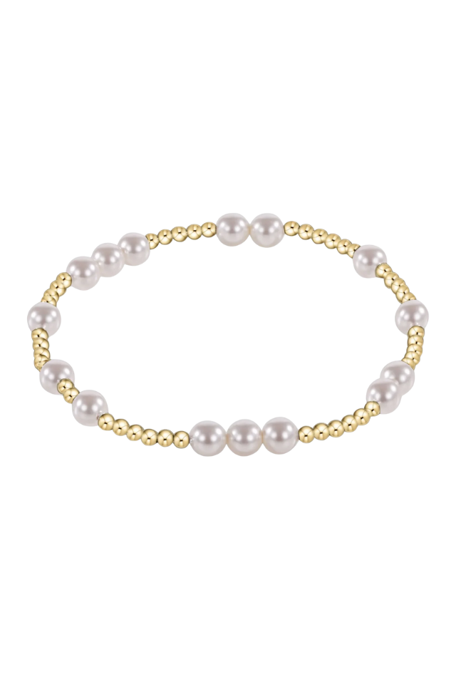 Pearl bracelet with gold accents on a white background. gold. silver. enewton. tarnishfree. metallic. stackable. bracelets.
