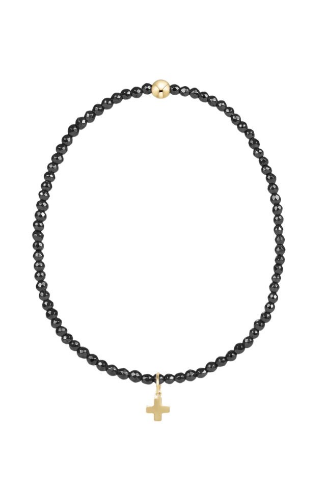 Black beaded necklace with a gold cross pendant on a white background. gold. silver. enewton. tarnishfree. metallic. stackable. bracelets.