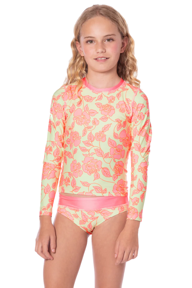 Young girl wearing a floral long-sleeve swimsuit on a white background maaji rashguard set 