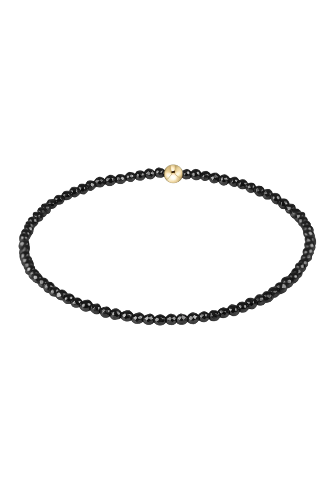 Black beaded necklace with a gold clasp on a white background. gold. silver. enewton. tarnishfree. metallic. stackable. bracelets.